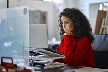 woman at home office looking focused at laptop