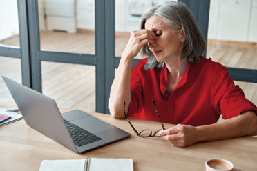 woman working on computer feeling exhausted