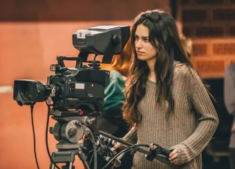 Woman looking into a camera on the set of a movie