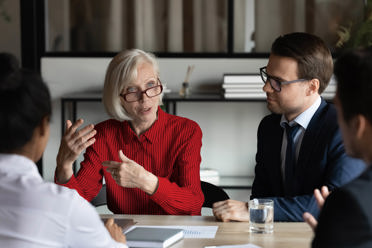 people sitting in conference room looking at laptop