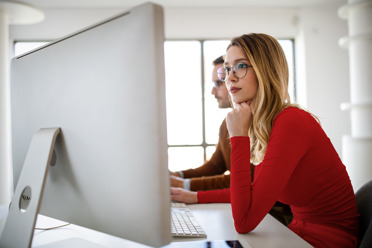 young woman looking focused at computer