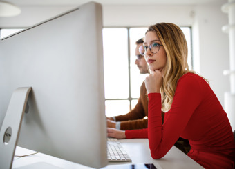 young woman looking focused at computer