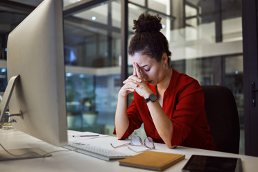 woman in dark office looking frustrated