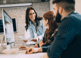 modern open office with three people discussing by computer