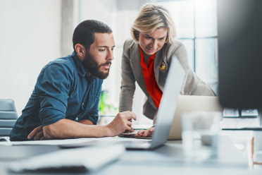 man and woman looking focused at computer screen