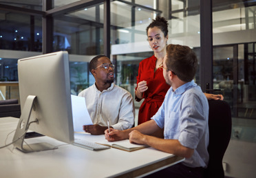 three people talking in office at evening