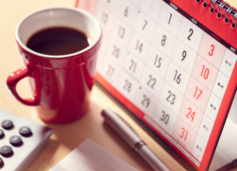 Paper calendar and cup of coffee