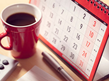 Paper calendar and cup of coffee